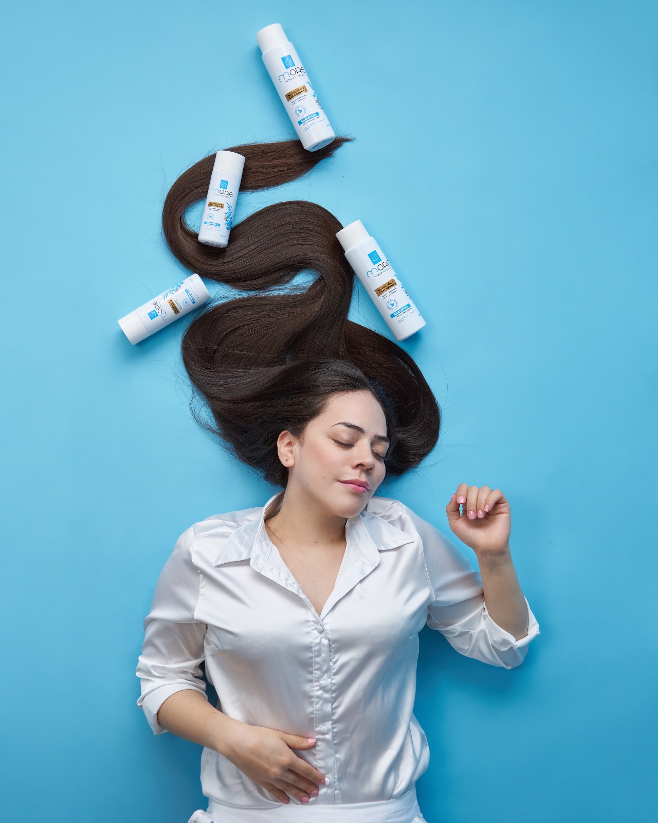 Cabello largo ondulado rodeado de productos MORE